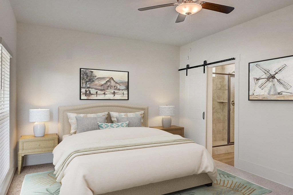 A bedroom with a bed, two lamps, and two pictures on the wall.