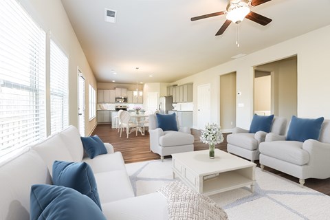 a living room with blue and white furniture and a kitchen