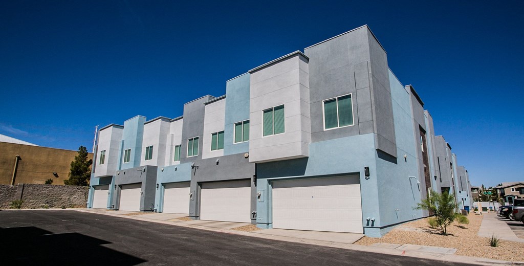 the exterior of a building with white and blue doors