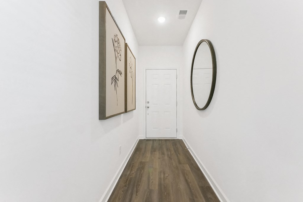 Welcoming hallway with warm wood flooring throughout