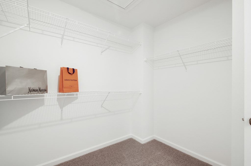 a room with white walls and a shelf with bags on it