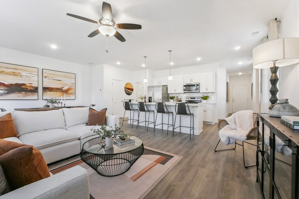 a living room with a couch and a table in front of a kitchen
