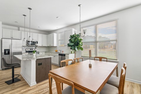 a kitchen with white cabinets and a wooden table