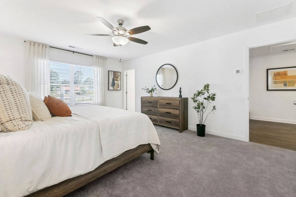 Serene master bedroom with natural light and ceiling fan