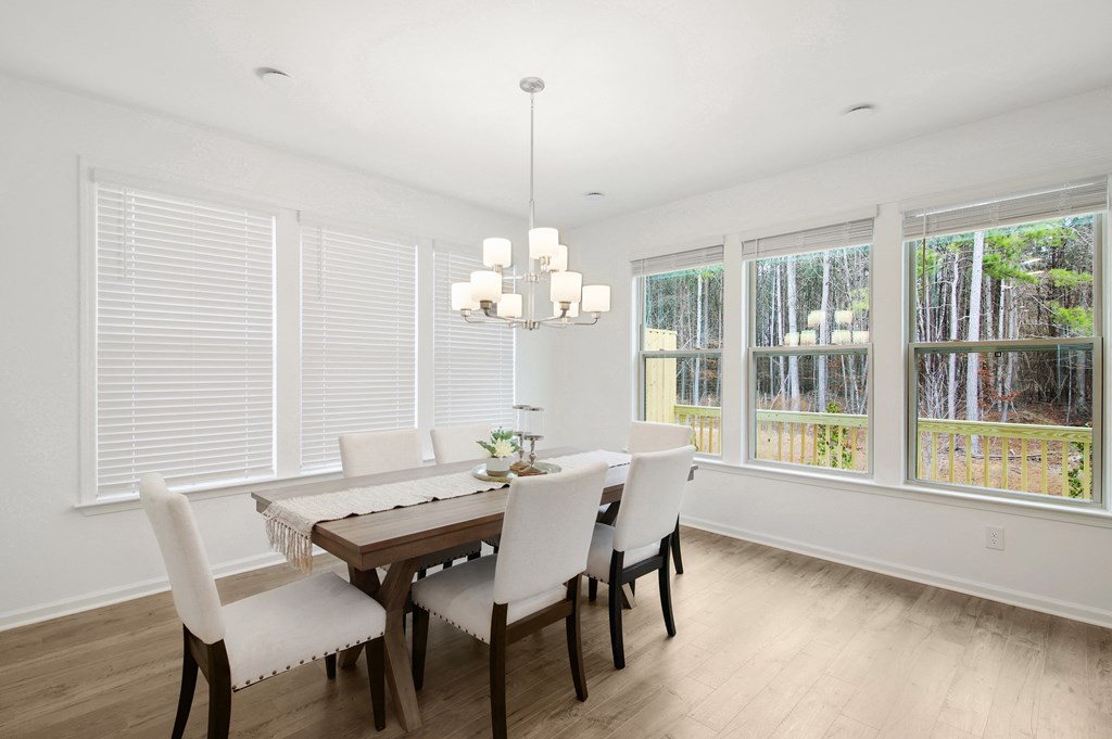 a dining room with a wooden table and white chairs