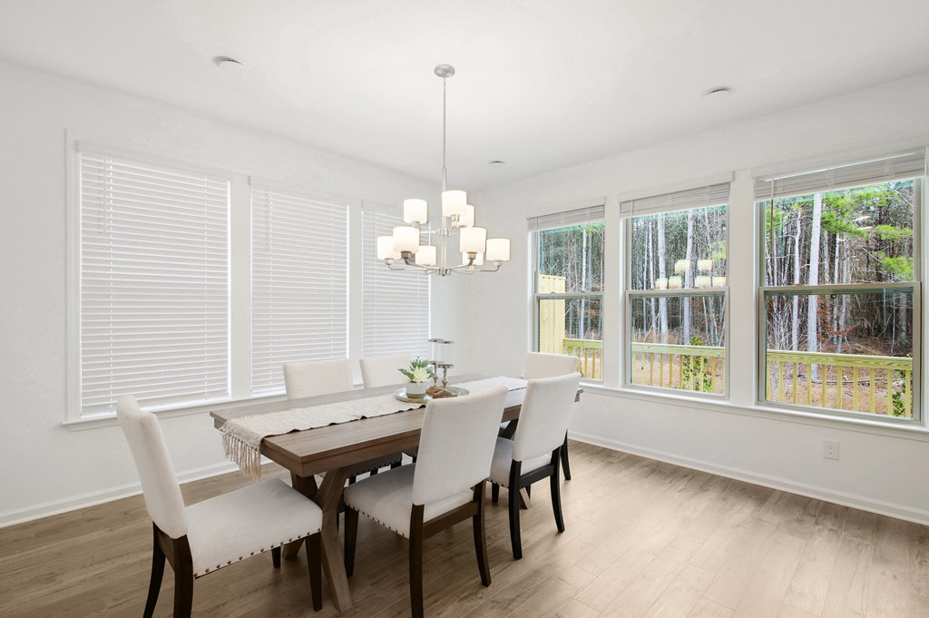 a dining room with a wooden table and white chairs