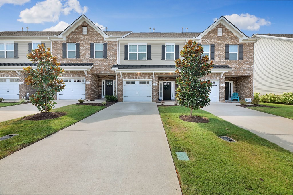 A row of houses with a driveway in the middle.