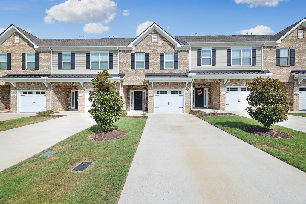 A row of houses with garages and driveways.