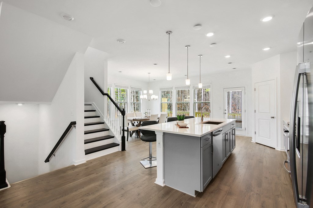 a living room with a kitchen and a staircase