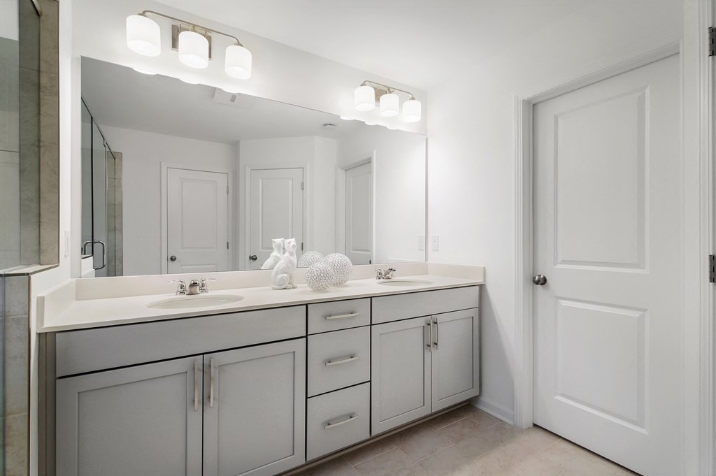 a white bathroom with a large mirror and two sinks
