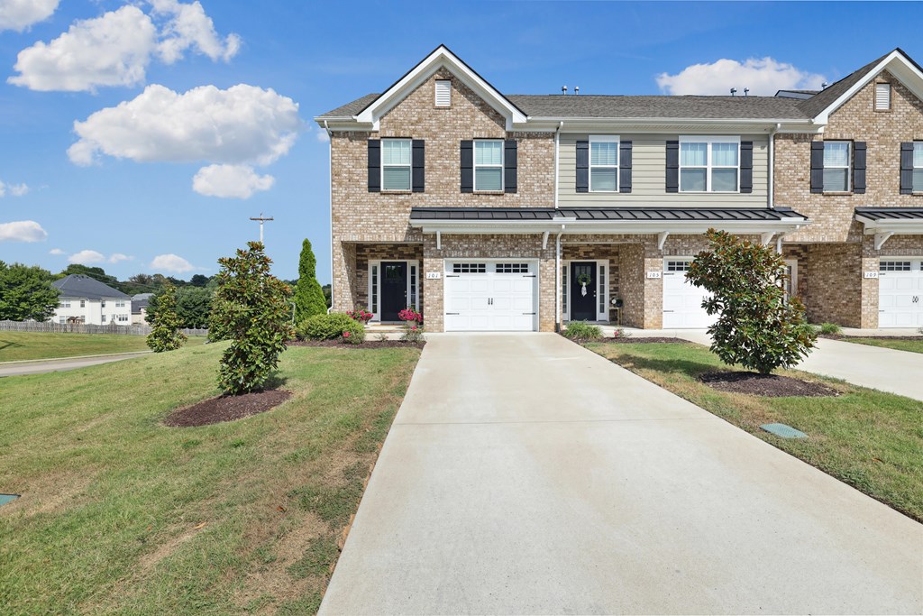 A large house with a driveway in front.