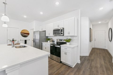 A modern kitchen with white cabinets and stainless steel appliances.