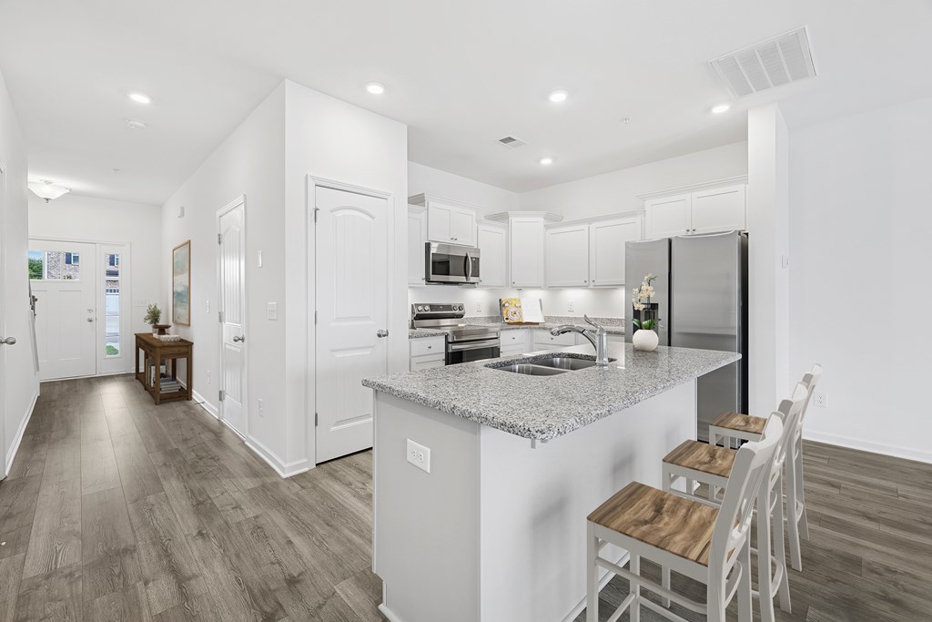 A modern kitchen with a large island and white cabinets.