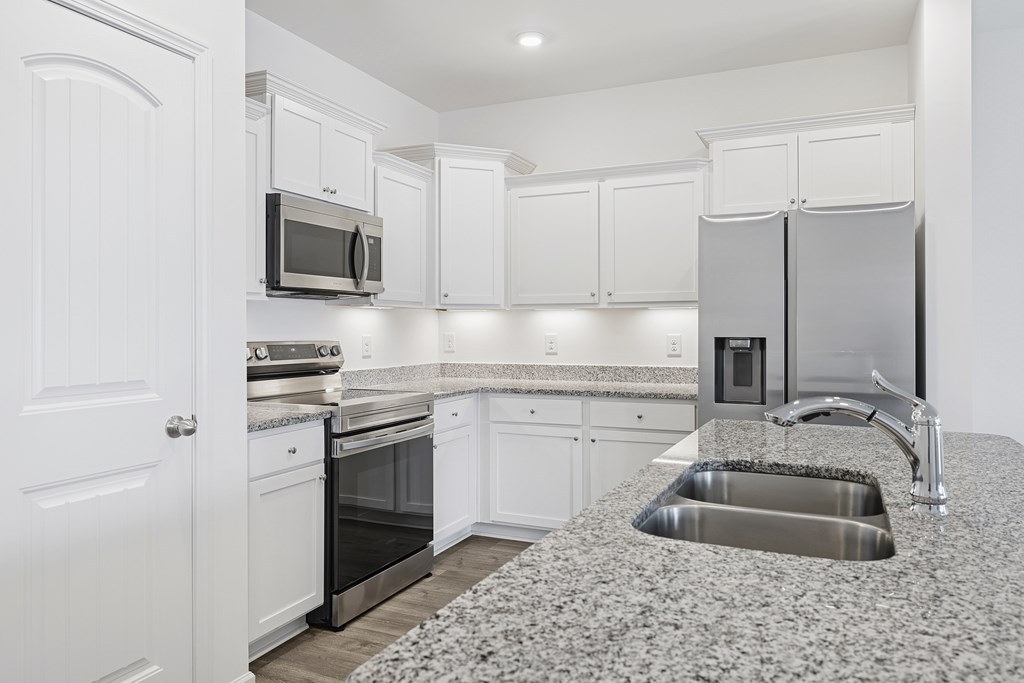 A kitchen with granite countertops and stainless steel appliances.