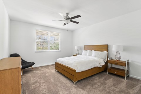 a bedroom with a bed and a ceiling fan