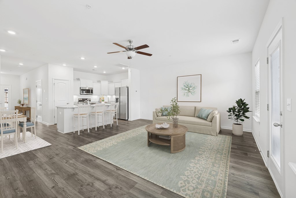 A living room with a couch, coffee table, and a dining table.