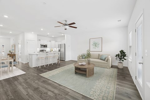 A living room with a couch, coffee table, and a dining table.