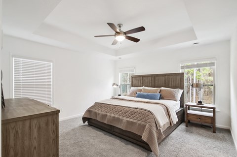a bedroom with a large bed and a ceiling fan