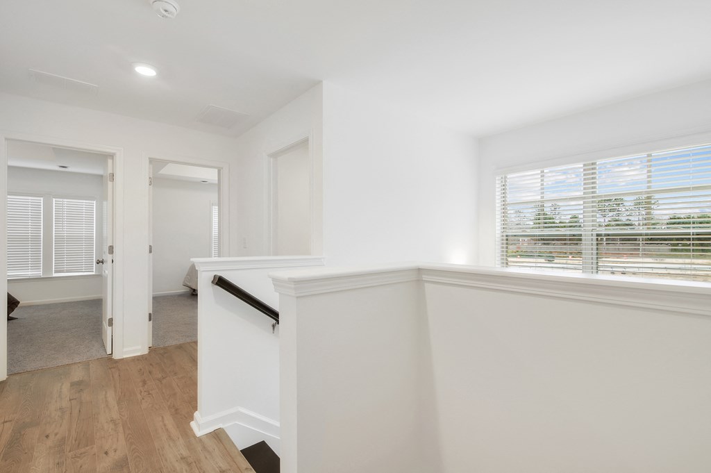 a renovated living room with white walls and wood flooring