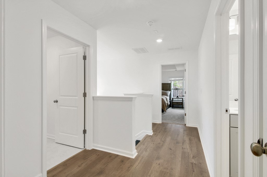 a white kitchen with white walls and white cabinets and a hallway with a white door