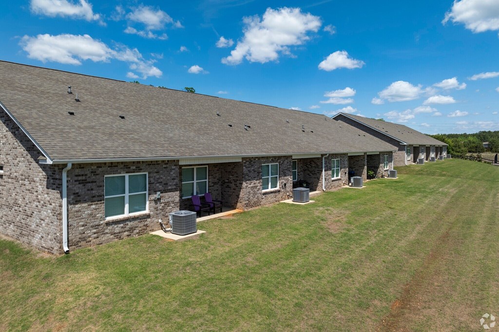 A row of houses with a grassy field in front.