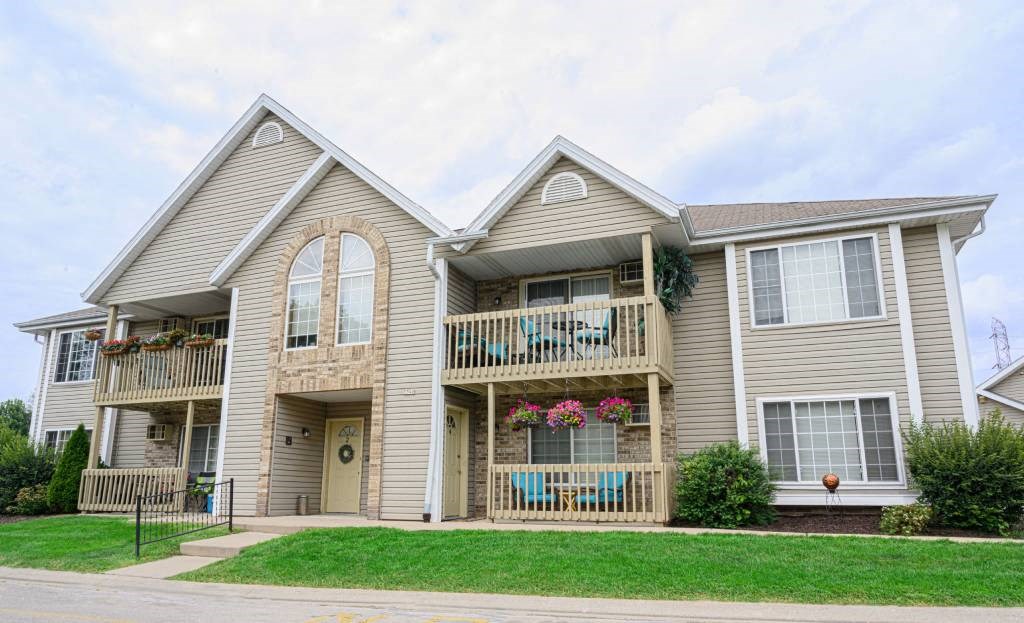 a house with two balconies and a lawn