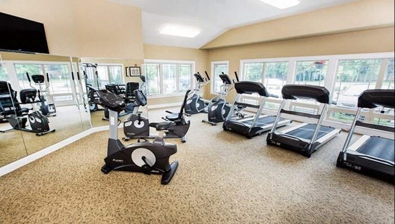 a gym with a lot of exercise equipment and windows