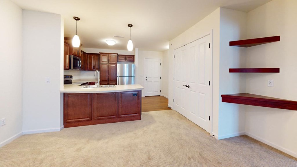 a kitchen and living room with wood cabinets and a counter