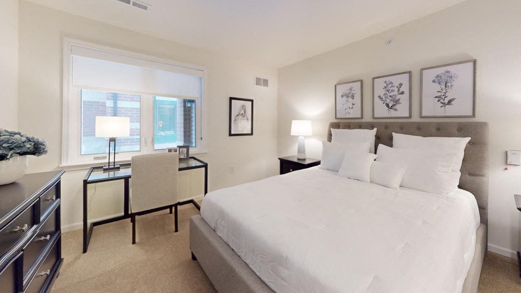 a white bedroom with a large bed and a window