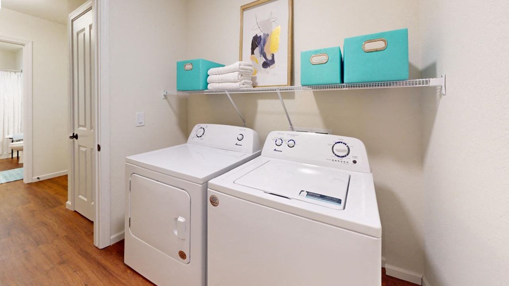 a washer and dryer in a room with a shelf on the wall