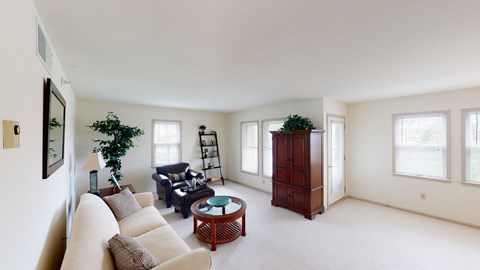 a living room with white walls and white carpet