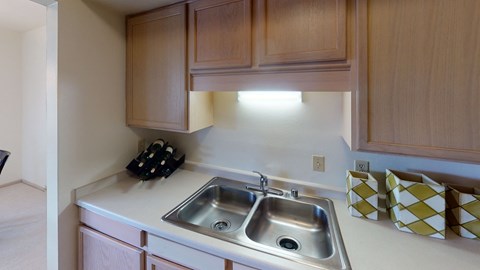 a kitchen with wooden cabinets and a stainless steel sink