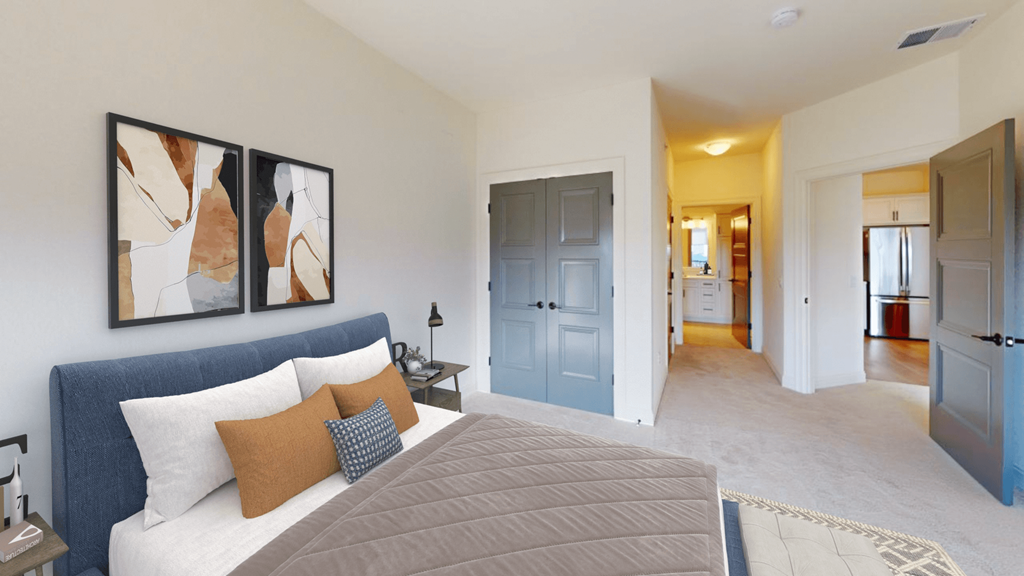 a bedroom with a large bed and a hallway with a bathroom