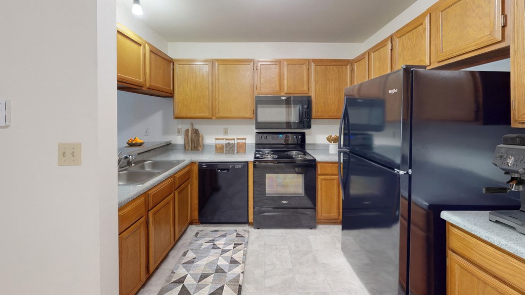 a kitchen with black appliances and wooden cabinets