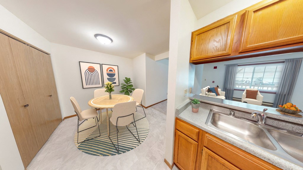 a dining room with a table and chairs and a kitchen with a sink