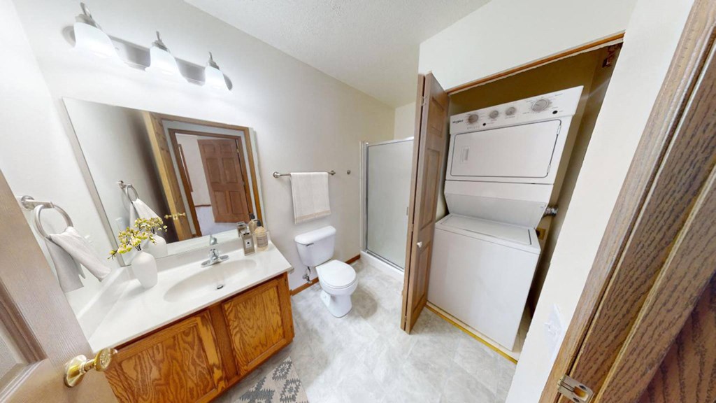 a bathroom with a sink toilet and a washer and dryer