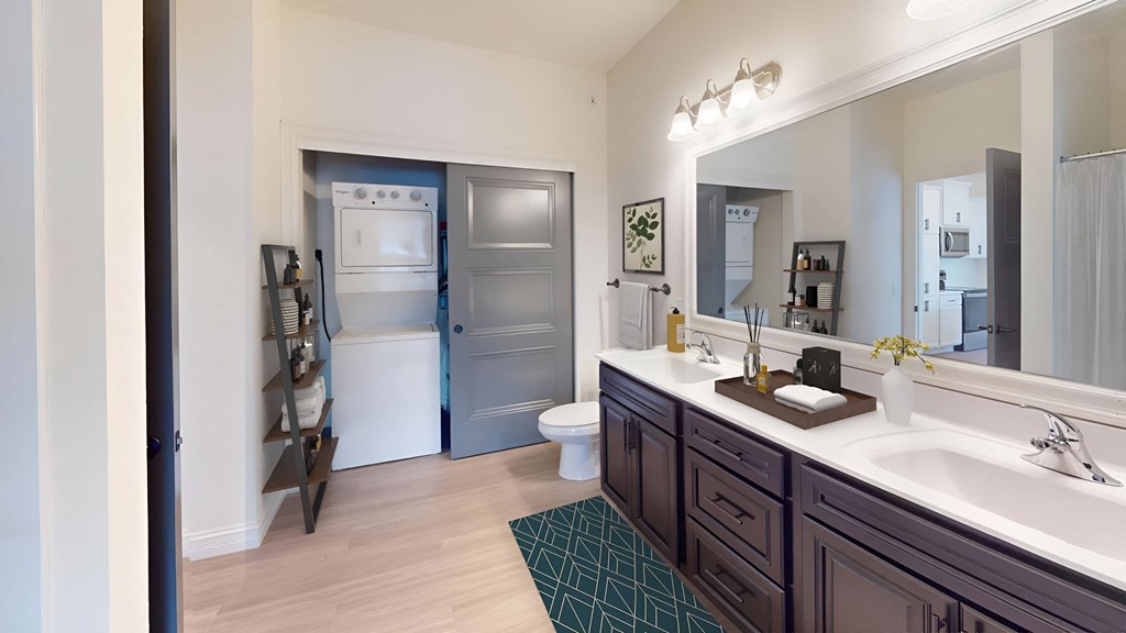 a bathroom with a large mirror and a sink and a toilet