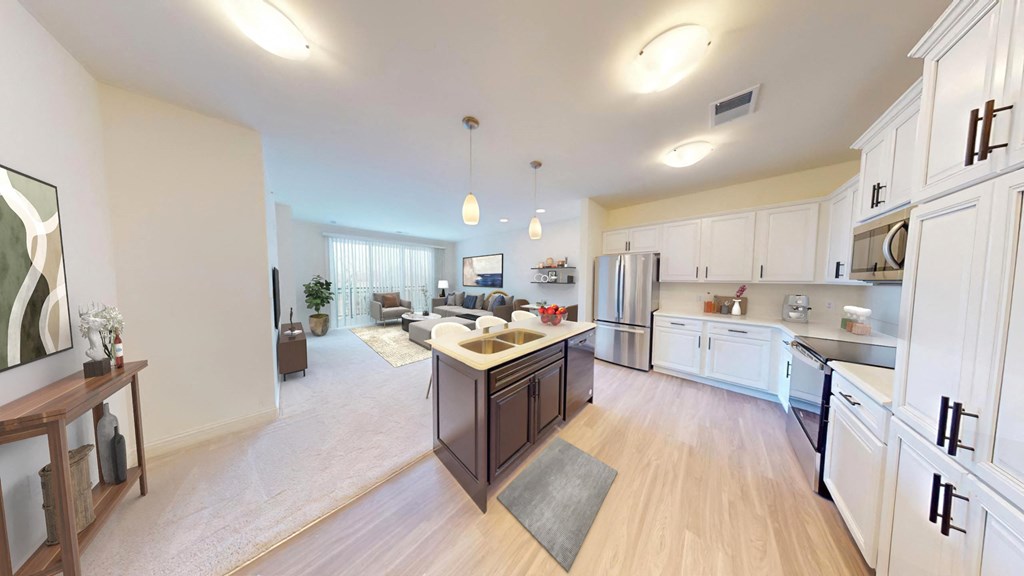 an open kitchen and living room with white cabinets and stainless steel appliances