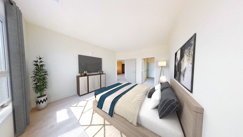 A bedroom with a bed, a television, and a potted plant.