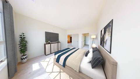 A bedroom with a bed, a television, and a potted plant.