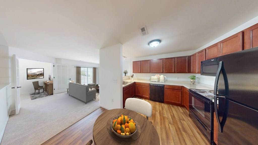 A modern kitchen with a bowl of fruit on the table.