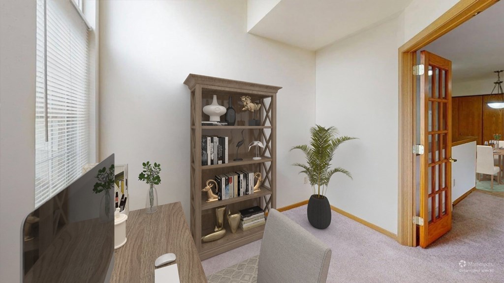 A room with a bookshelf, a chair, and a plant.