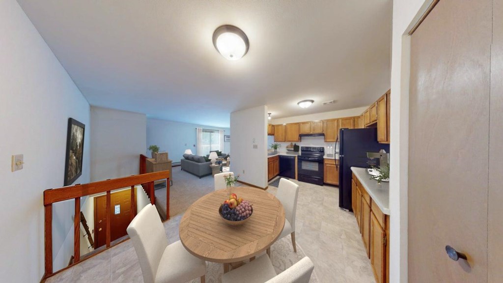 A modern kitchen with a dining table set for two.