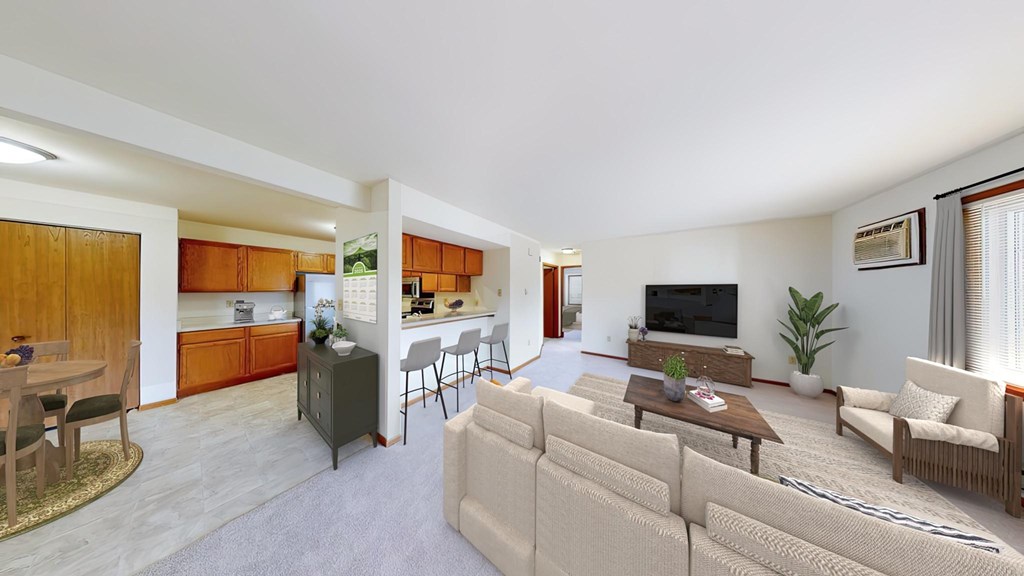A living room with a couch, chairs, and a television.