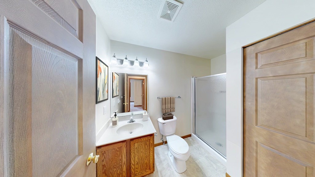 A bathroom with a toilet, sink, and mirror.