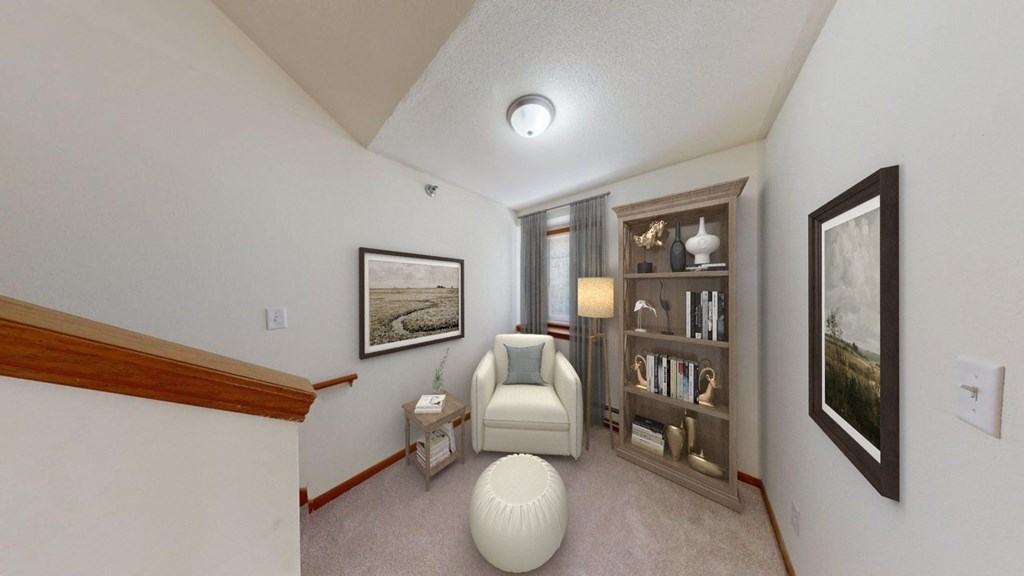 A living room with a white chair and a bookshelf.