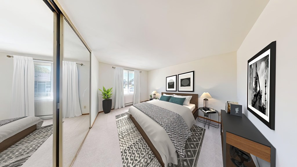 A bedroom with a large bed and a mirror on the wall.