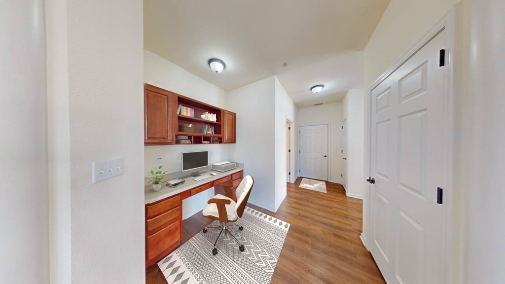 A home office with a desk, chair, and computer.