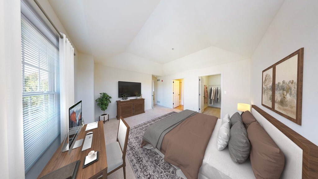 A bedroom with a bed, desk, and chair.