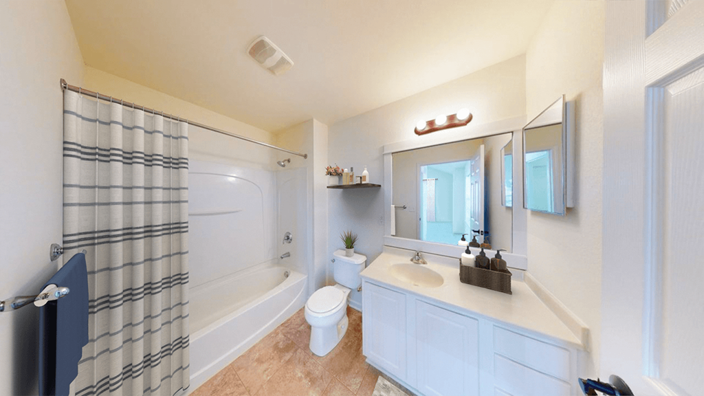 A bathroom with a toilet, sink, and shower.